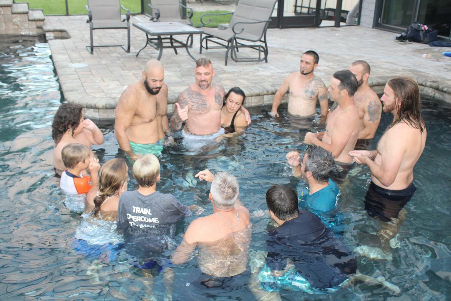 Raylan Heck, center (with wife), founder and CEO of Warrior’s Peace, teaches the group a pool lesson on balancing control and surrender to respond rather than overreact to issues during an early-morning session.